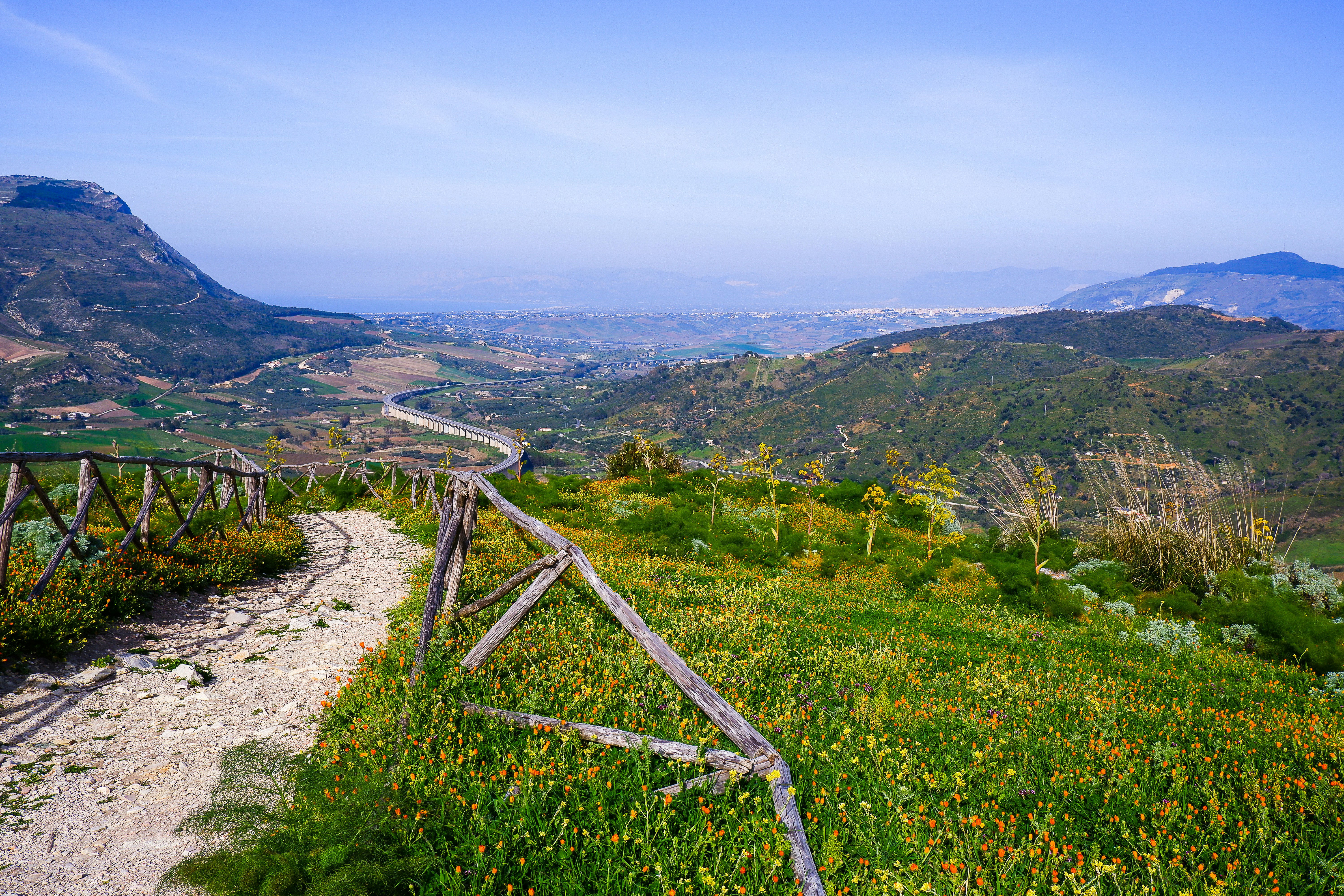 a wooden fence sitting on top of a lush green hillside