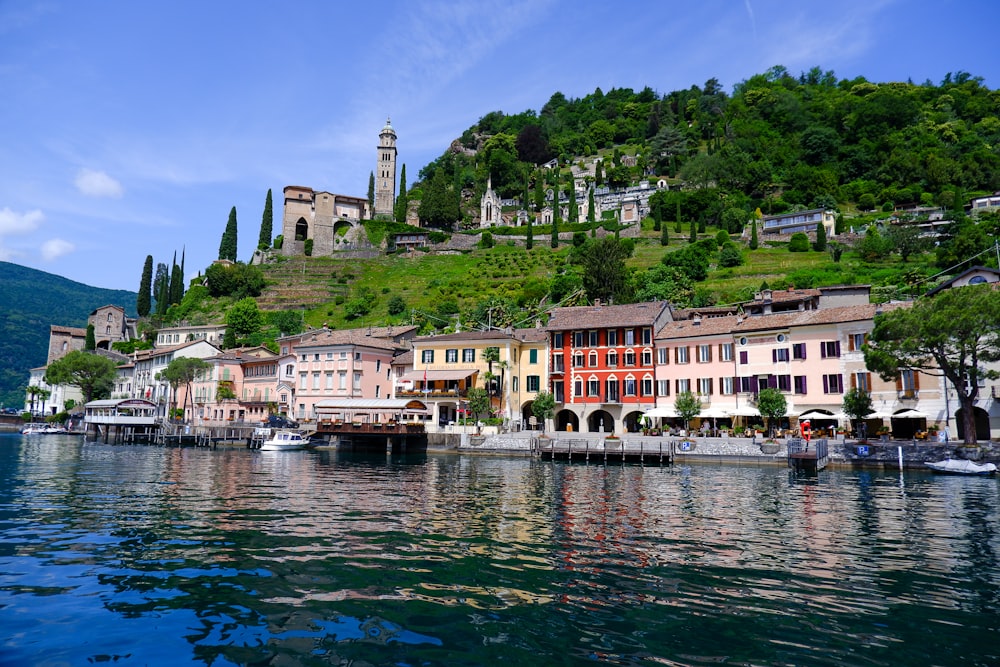 a group of buildings sitting on top of a lush green hillside