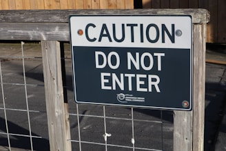A sign attached to a wooden and wire fence reads CAUTION DO NOT ENTER, indicating restricted access. The sign has black and white text and includes a small emblem for the Swinomish Indian Tribal Community.
