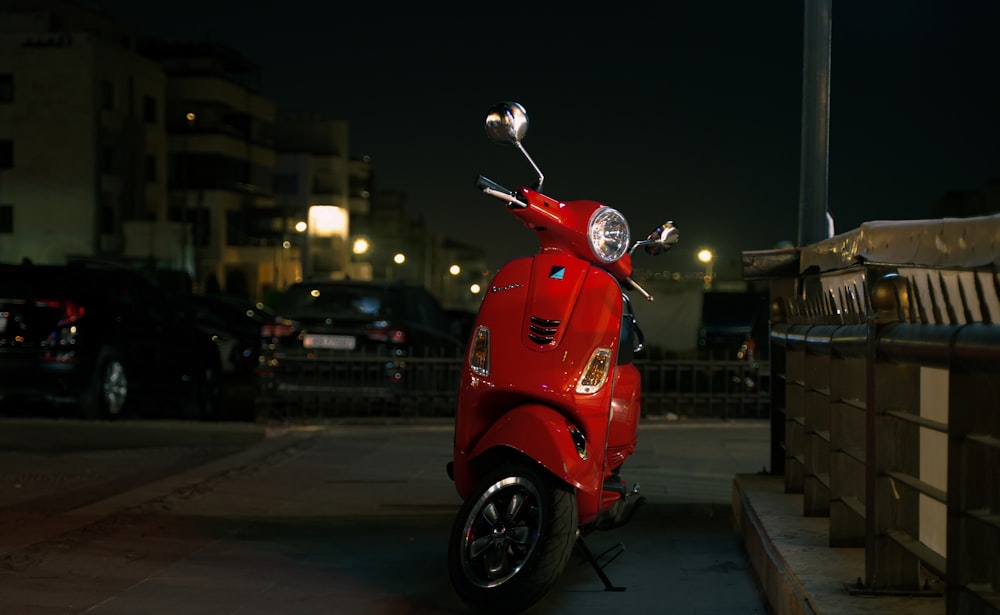 a red scooter parked on the side of the road