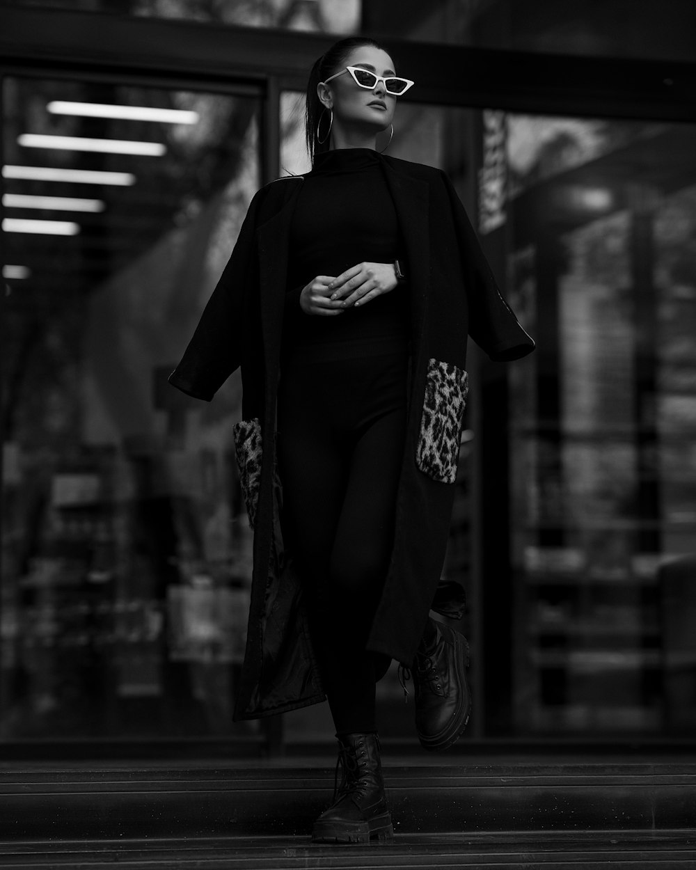 a woman walking down a street in a black and white photo