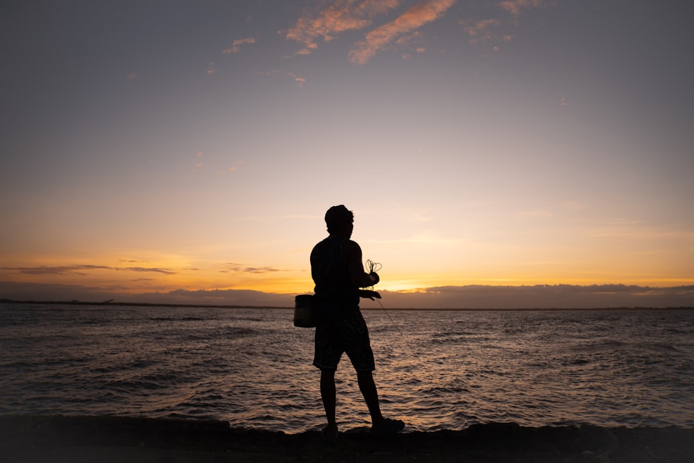 a man standing on a beach next to the ocean