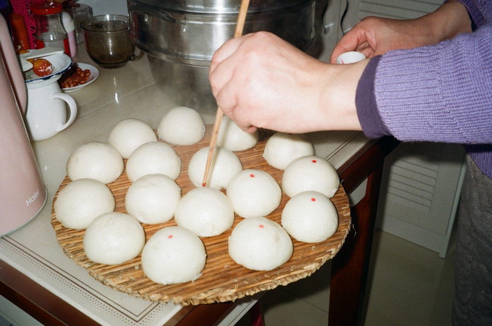 a person chopping up some food on a wooden tray