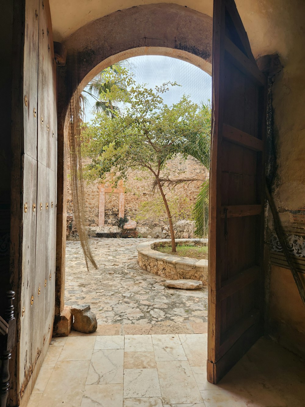 an open door leading to a courtyard with a hammock