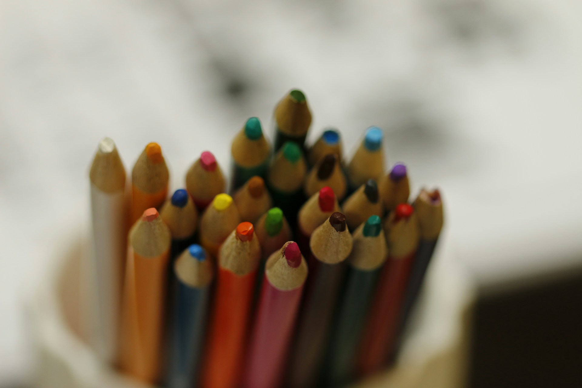 a group of colored pencils sitting in a cup