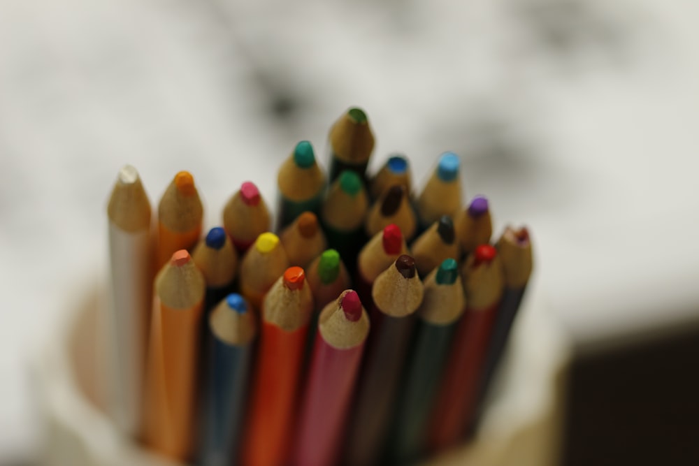 a group of colored pencils sitting in a cup