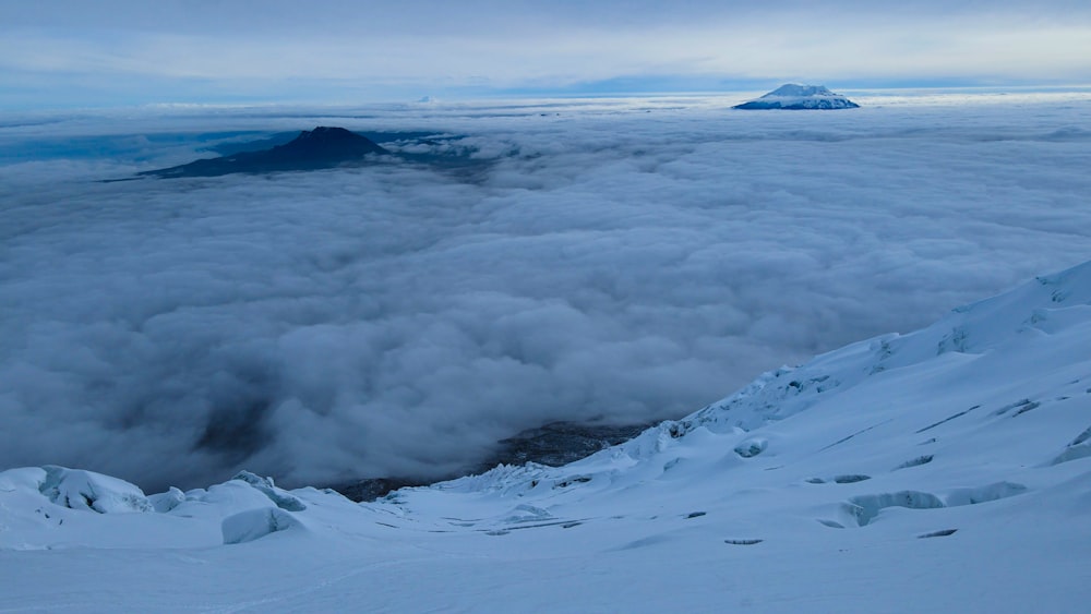 Una montaña cubierta de nieve y nubes bajo un cielo nublado