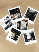 A collection of six Polaroid photographs scattered on a light brown surface. The images include various scenes: a magazine display, a vintage Pepsi sign, an interior with memorabilia, a religious poster, a white statue, and a storefront with awnings and framed pictures. Each photograph captures a moment with nostalgic and eclectic elements.