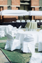 A smiling catering team serving food at an outdoor wedding.