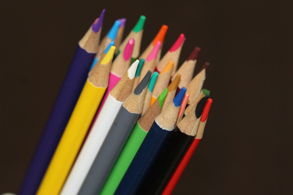 a group of colored pencils sitting next to each other