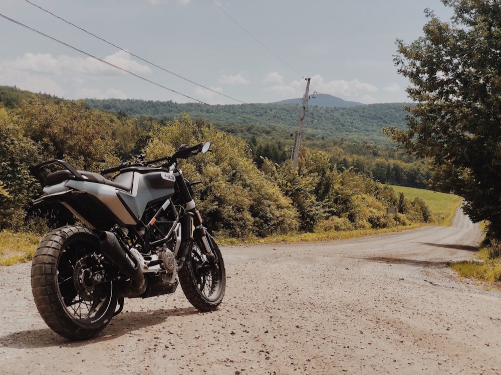 a motorcycle parked on the side of a dirt road