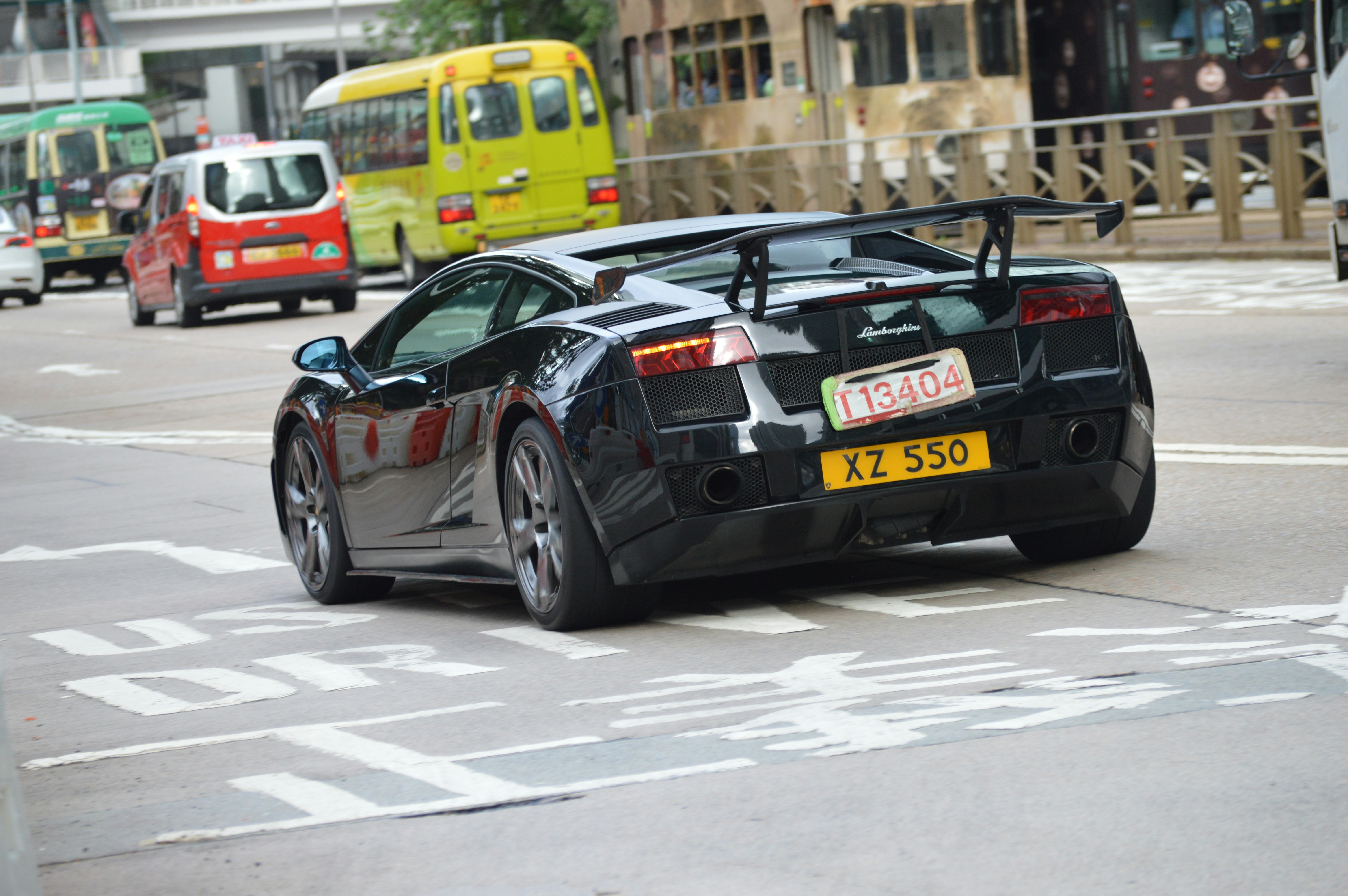 A black sports car driving down a city street photo – Free Car Image on ...