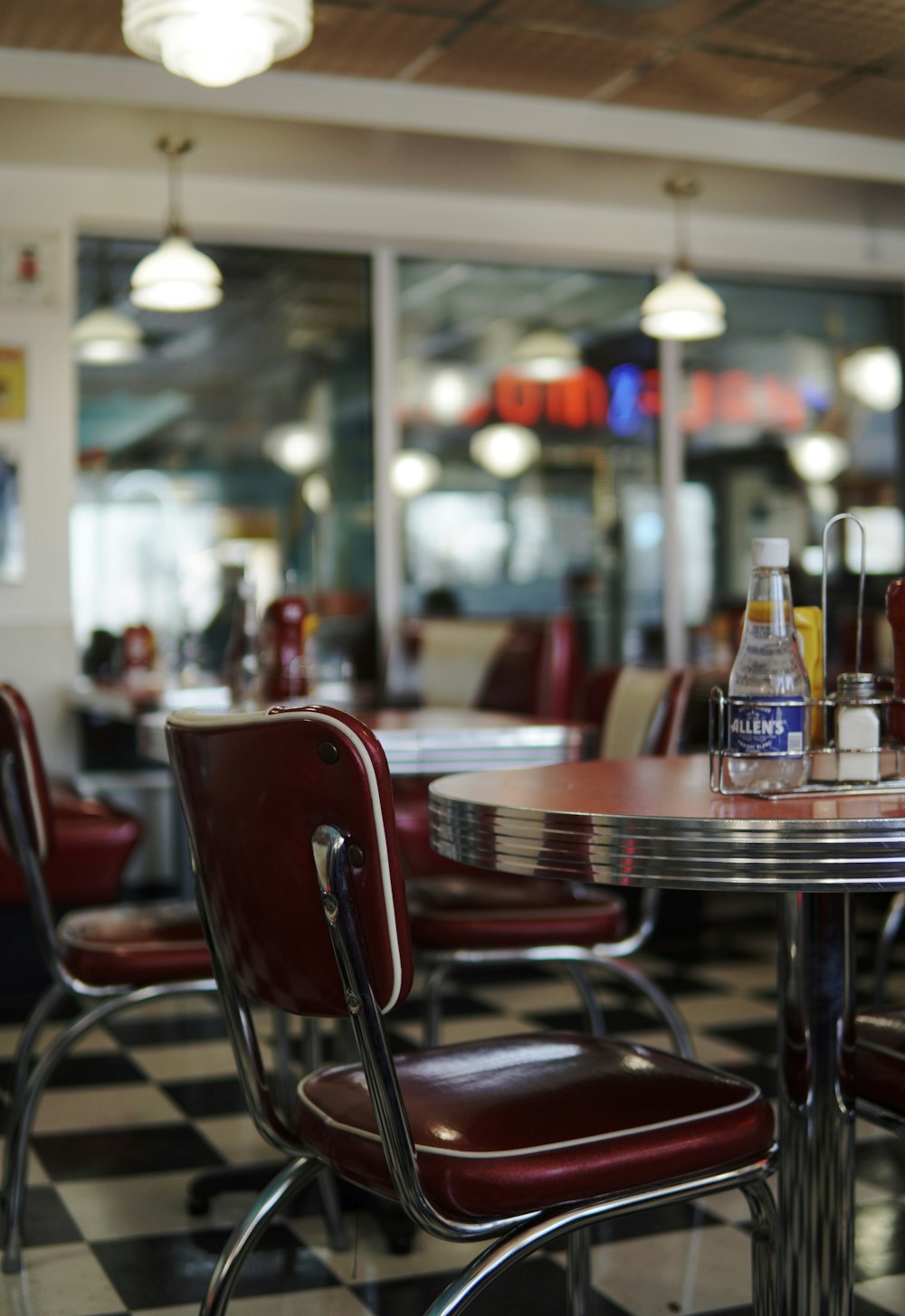 a restaurant with a checkered floor and red chairs