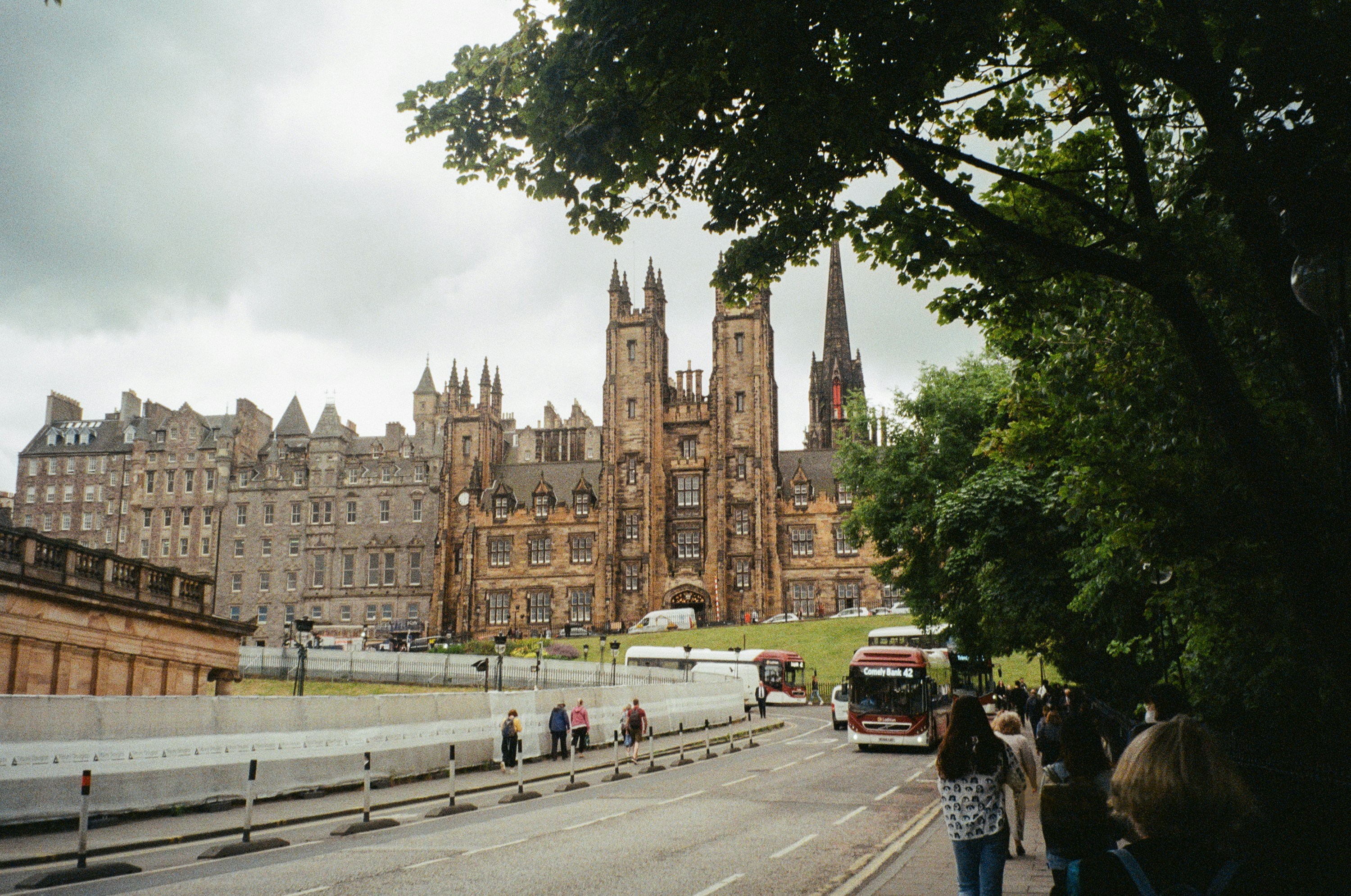 a group of people walking down a street in front of a large building