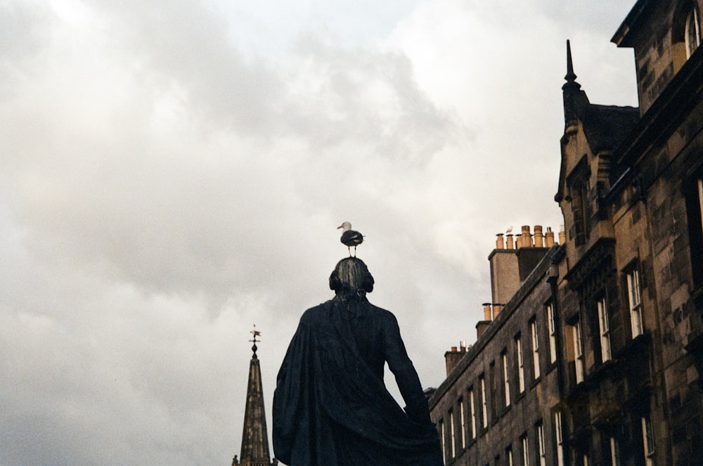 a statue of a woman with a bird on her head