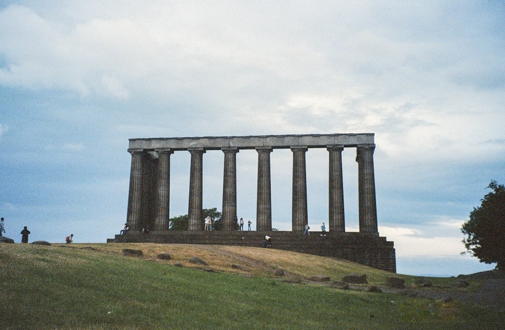 a large stone structure sitting on top of a lush green hillside