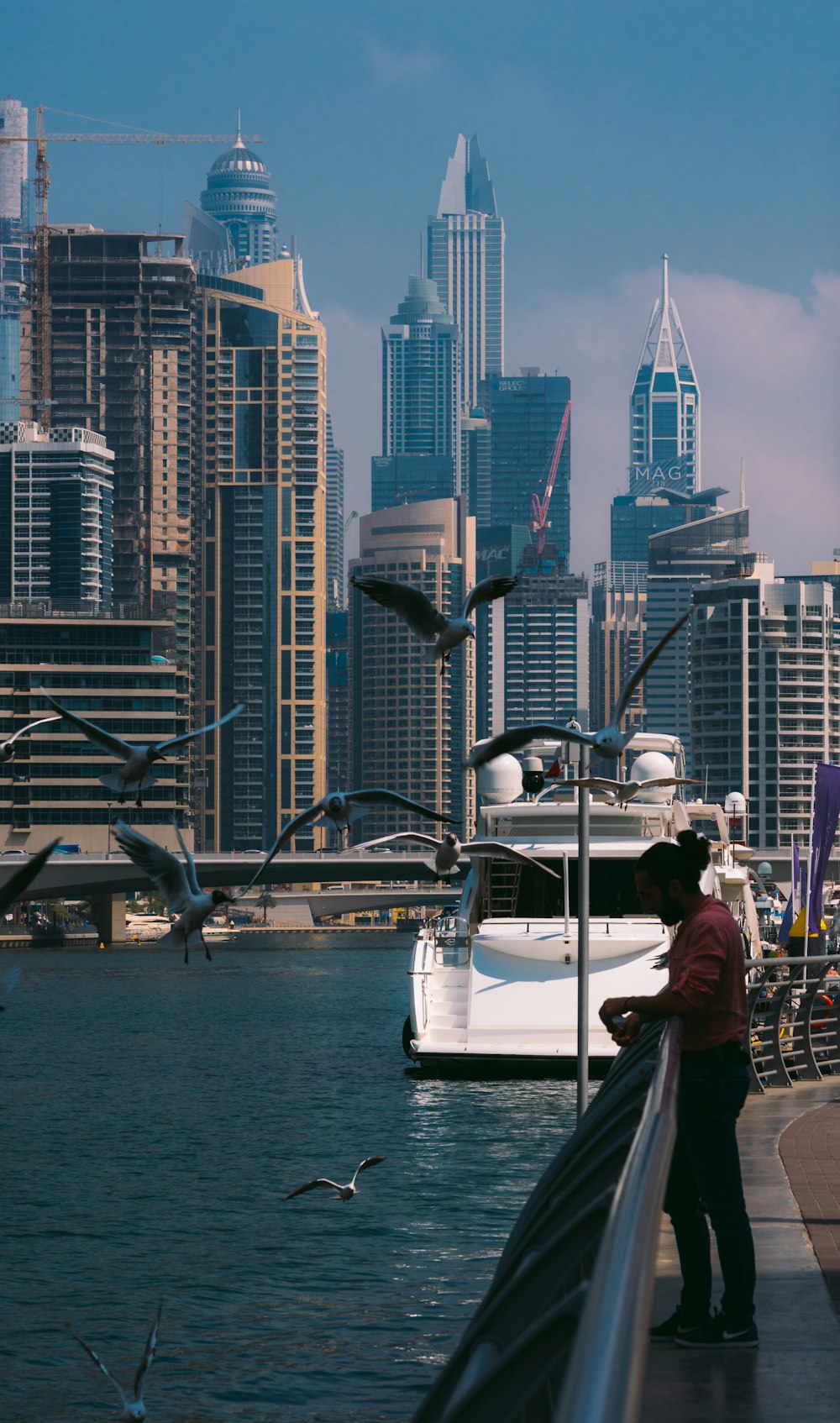 a man standing on a pier next to a body of water