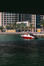 A vibrant photo of a speedboat cutting through the sparkling waters of the New York Harbor with the city skyline in the background under a clear blue sky.