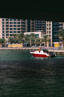 A vibrant speedboat cutting through the sparkling waters of New York Harbor with the city skyline in the background on a sunny day.