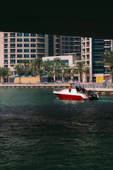 A vibrant speedboat cutting through the sparkling waters of New York Harbor with the city skyline in the background on a sunny day.