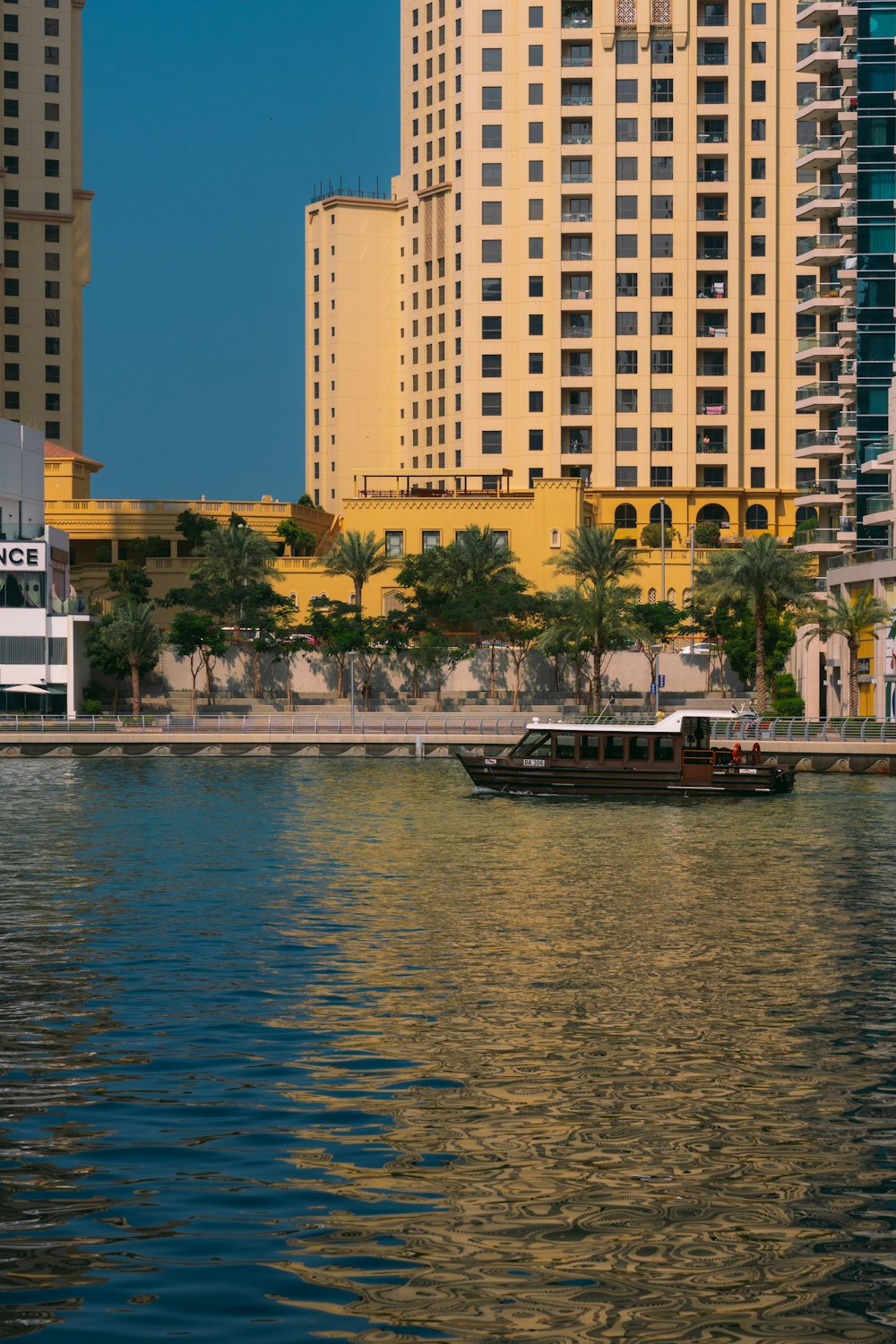a boat on the water in front of tall buildings