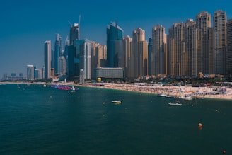 a beach in front of a city with tall buildings