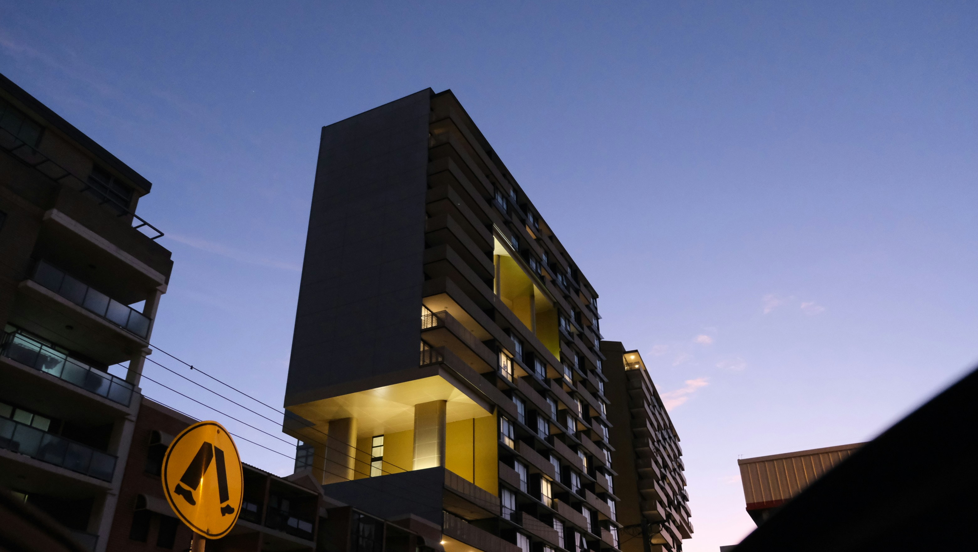 Un edificio alto sentado junto a una señal de tráfico