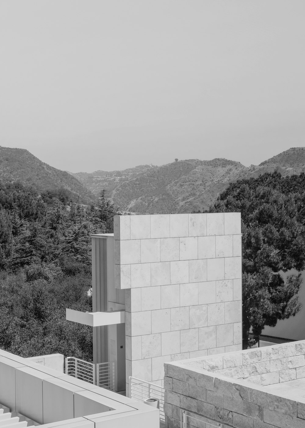 Una foto en blanco y negro de un edificio con montañas al fondo