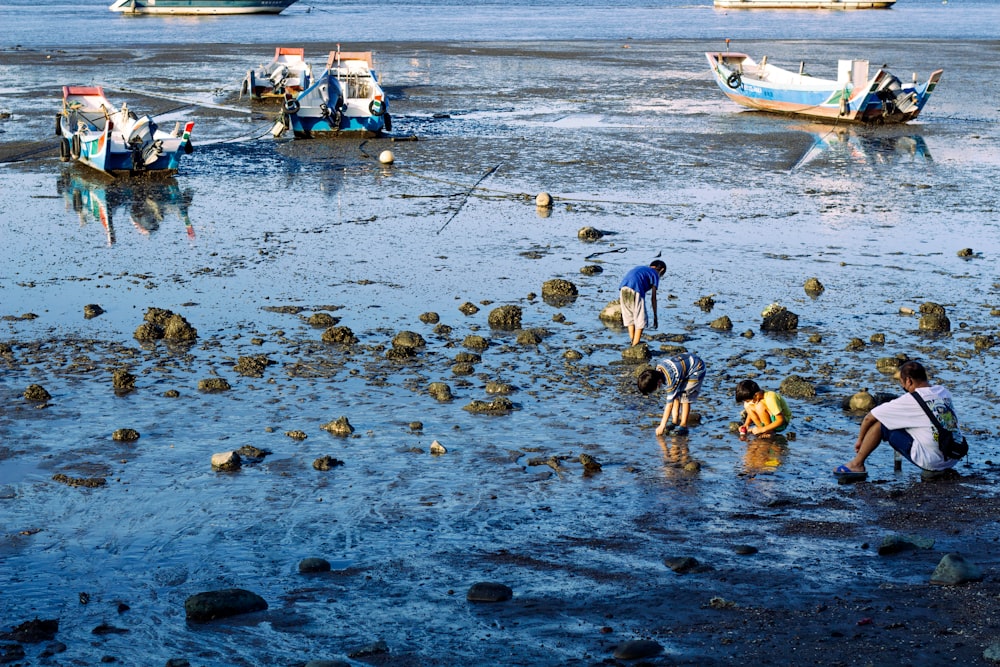 a group of people standing on top of a sandy beach