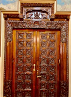 An elegant wooden interior door with intricate carvings and a warm finish.