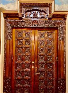 A sturdy wooden front door with intricate carvings and a polished finish.