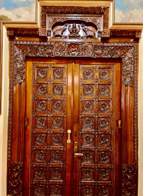 An elegant wooden interior door with intricate carvings and a warm finish.