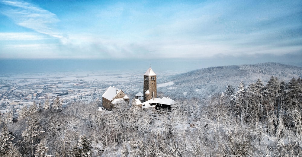 uma paisagem nevada com uma igreja no topo de uma colina