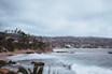 people swimming in the ocean on a cloudy day