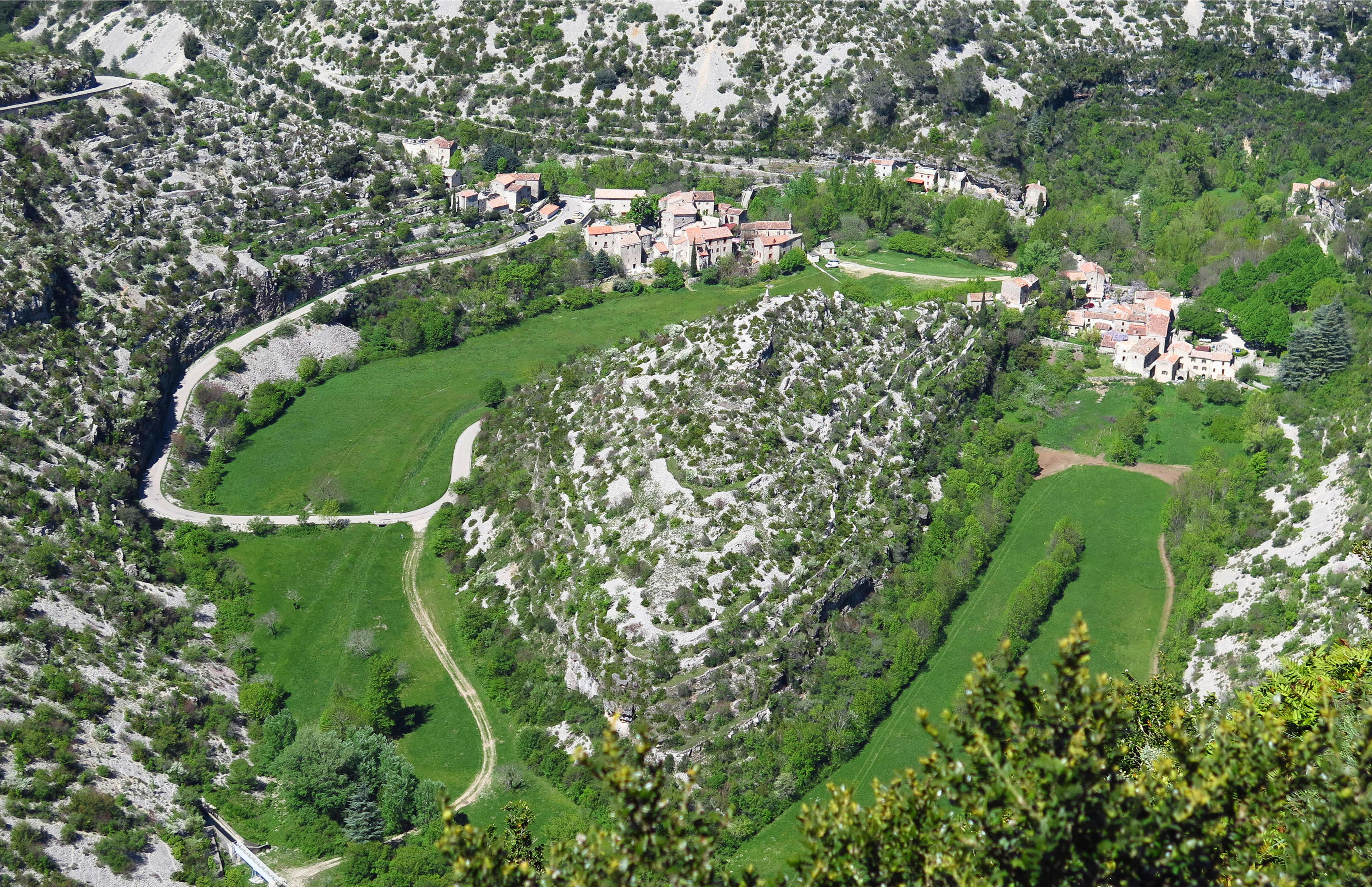 an aerial view of a lush green valley, La Cirque de Navacelles, France.