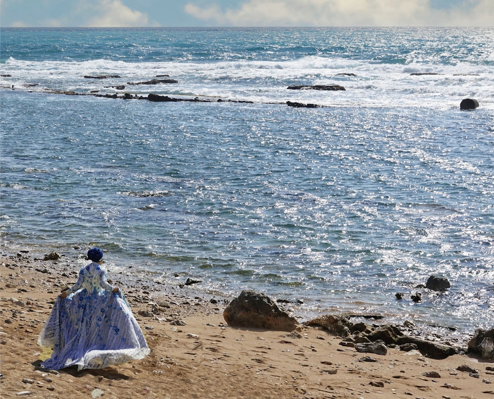 a woman standing on a beach next to the ocean