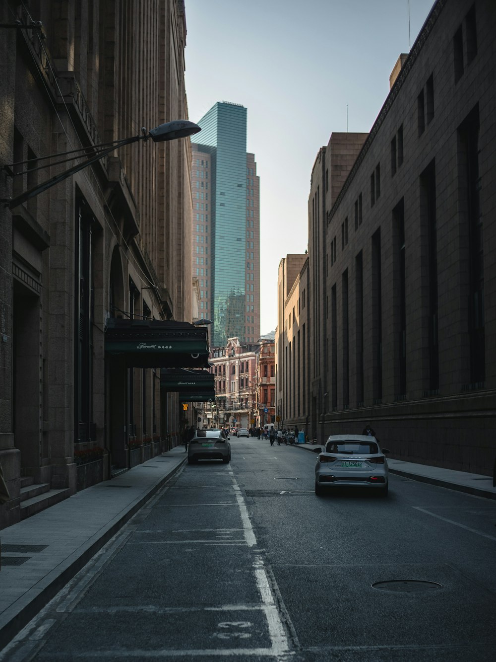 a car driving down a street next to tall buildings