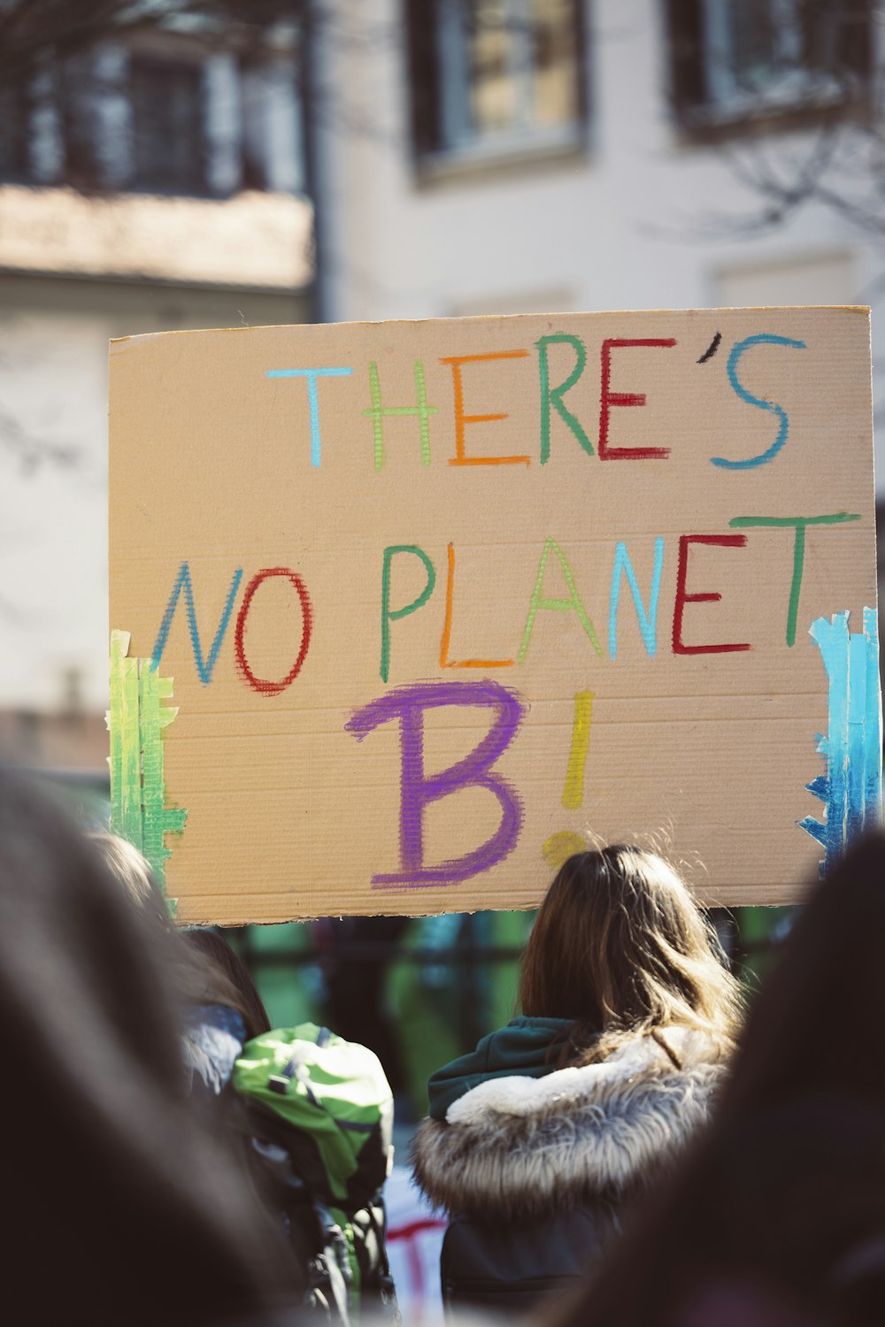 a person holding a sign that says there's no planet b