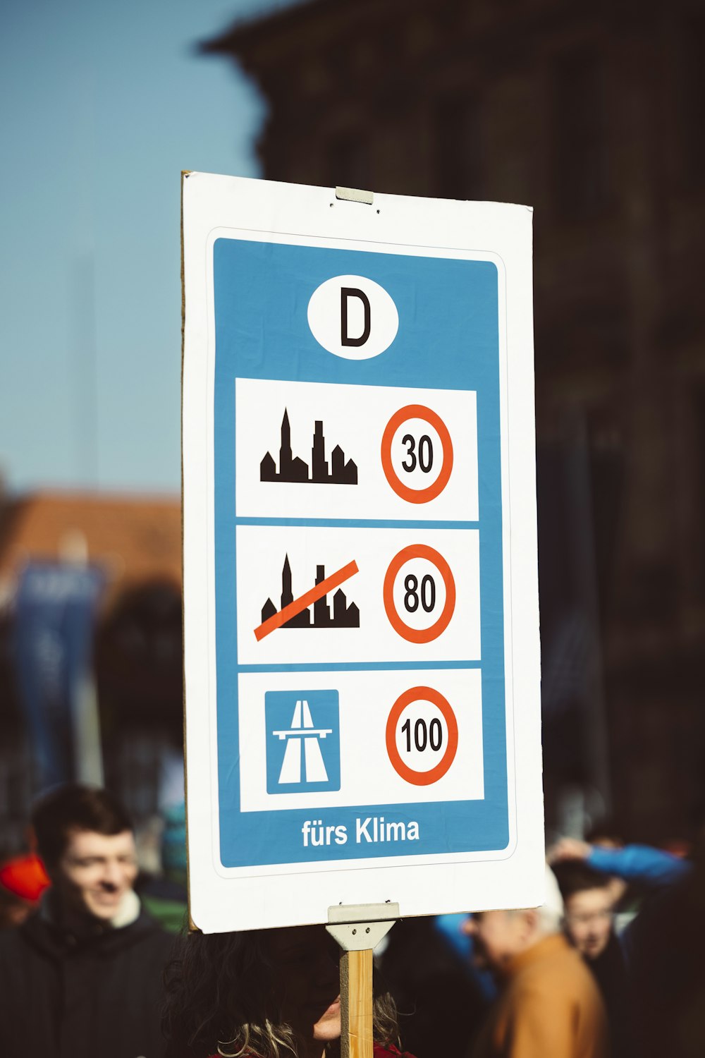 a blue and white street sign sitting on the side of a road