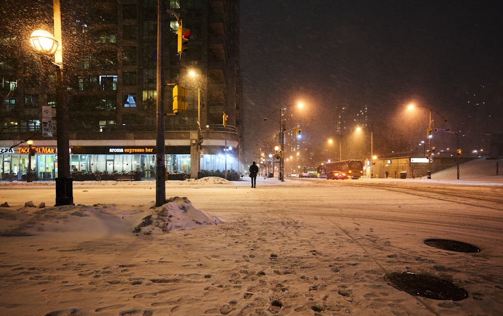 a city street is covered in snow at night