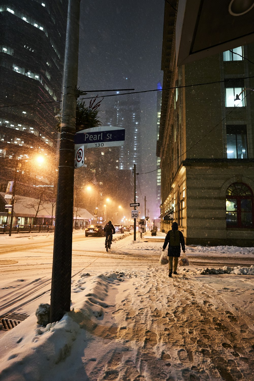 a person walking down a snowy street at night