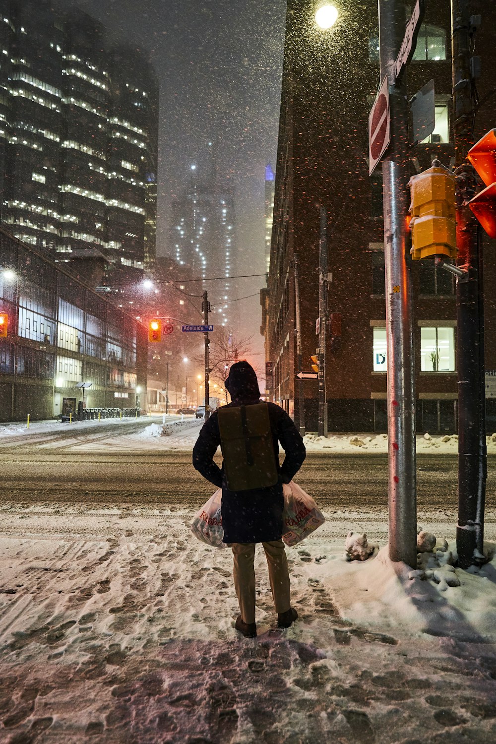 a person standing on a snowy street at night