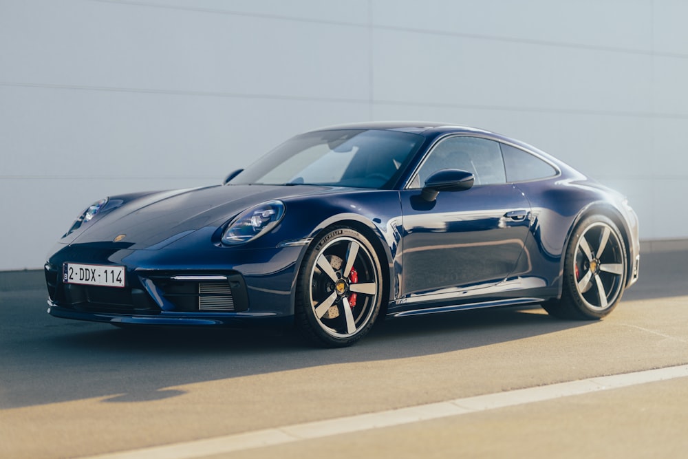 a blue sports car parked in front of a building