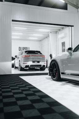Modern garage interior with technicians working on cars in a clean, professional setting.