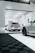 A satisfied customer smiling next to a sleek luxury car in a modern garage.