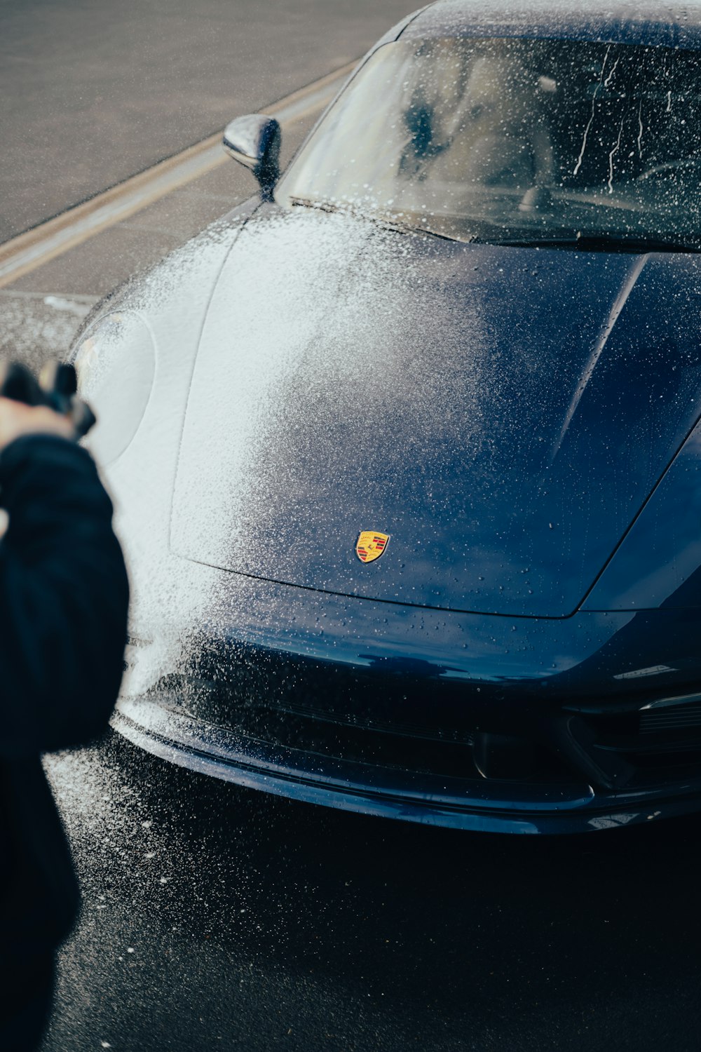 a person taking a picture of a blue sports car