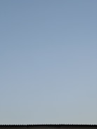Aerial view of a residential roof with a clear blue sky.