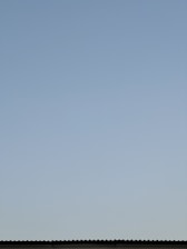 Aerial view of a residential roof with a clear blue sky.