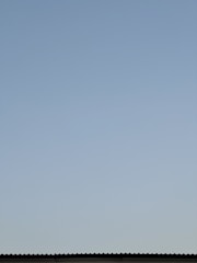 A completed roof with clean gutters and a clear sky backdrop.