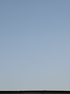Aerial view of a residential roof with a clear blue sky in the background.
